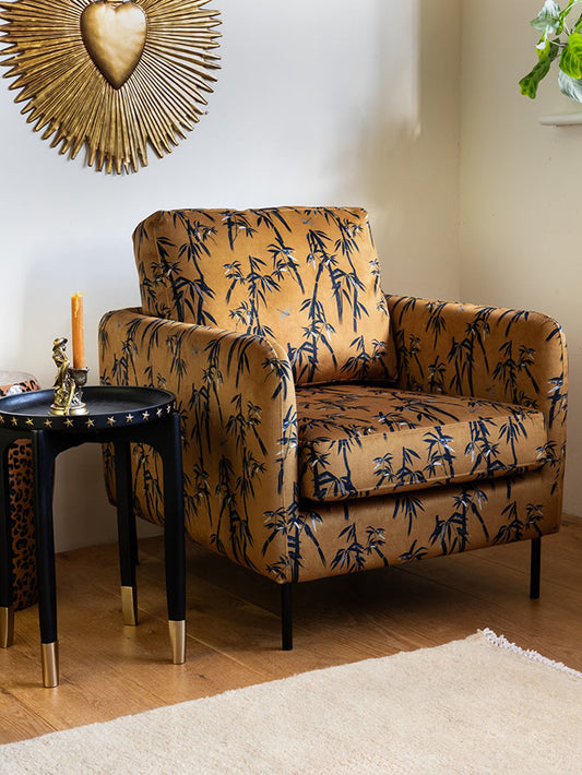 Le fauteuil Edie en bambou et velours doré