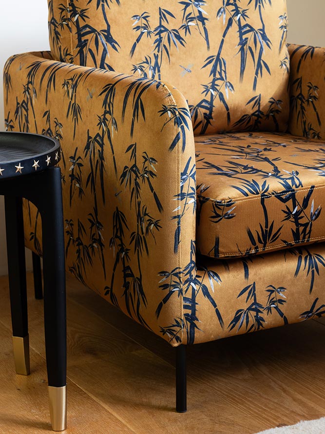 Le fauteuil Edie en bambou et velours doré