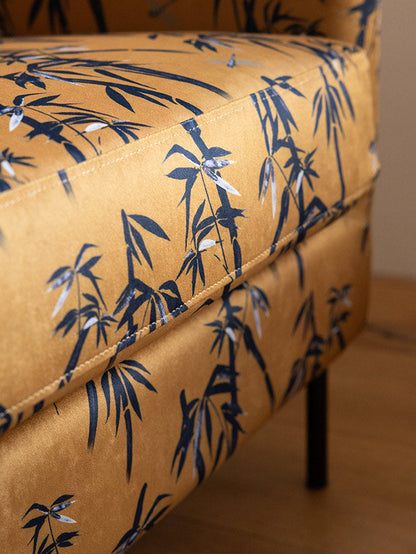 Le fauteuil Edie en bambou et velours doré